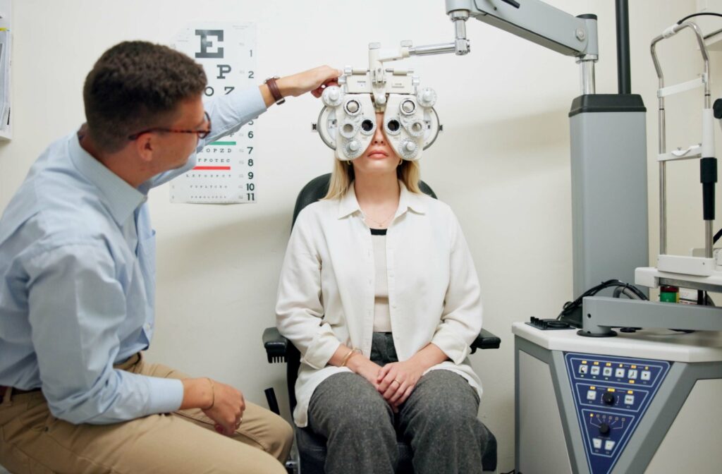 A person looking through a phoropter during their comprehensive eye exam.