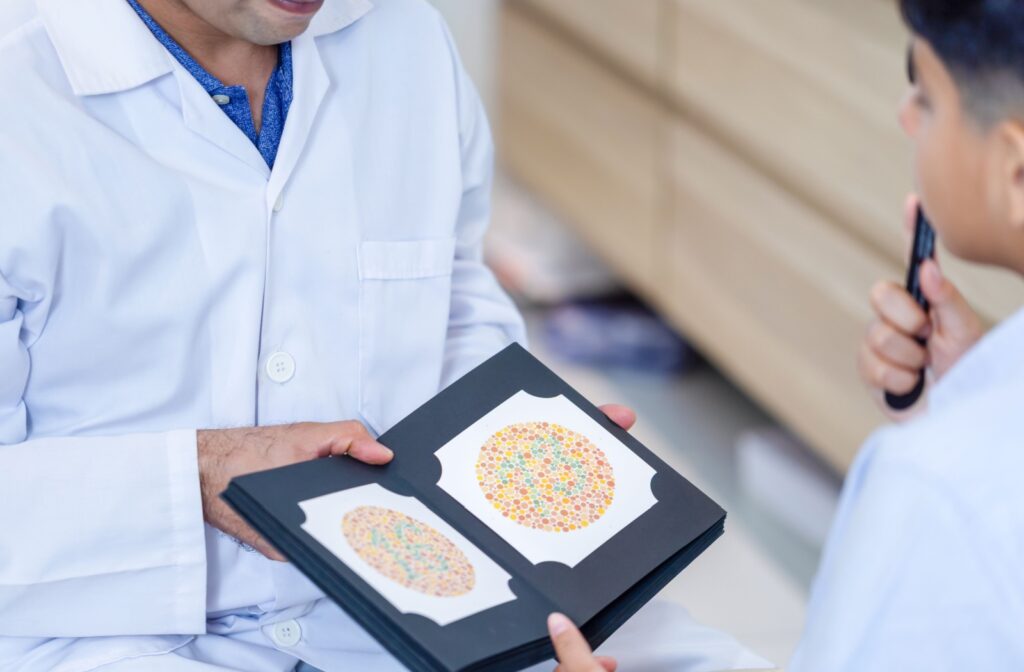 Optometrist showing a color blindness test booklet to a child during a vision screening