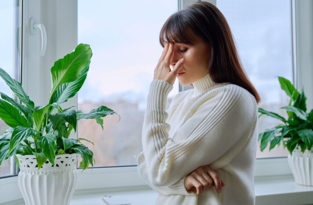 A woman holding her hand on her head, indicating stress.