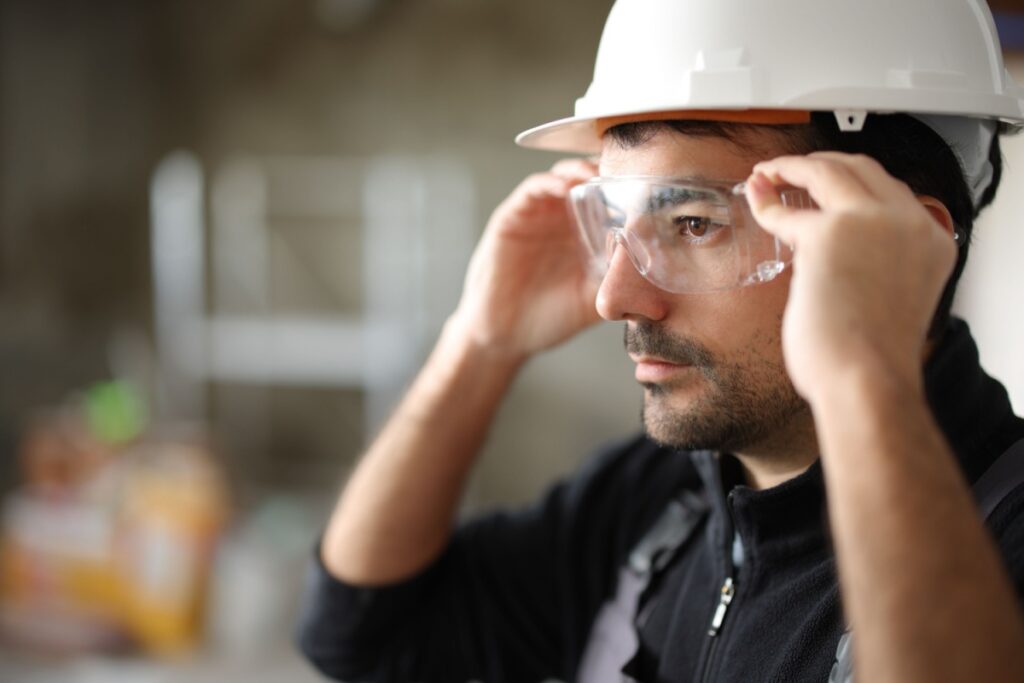 A person wearing eye protection at a construction site to protect their vision.