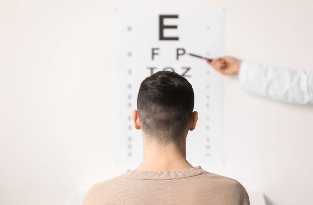 A person looking at a Snellen eye chart in an examine room at an optometry office to monitor for degenerative myopia.